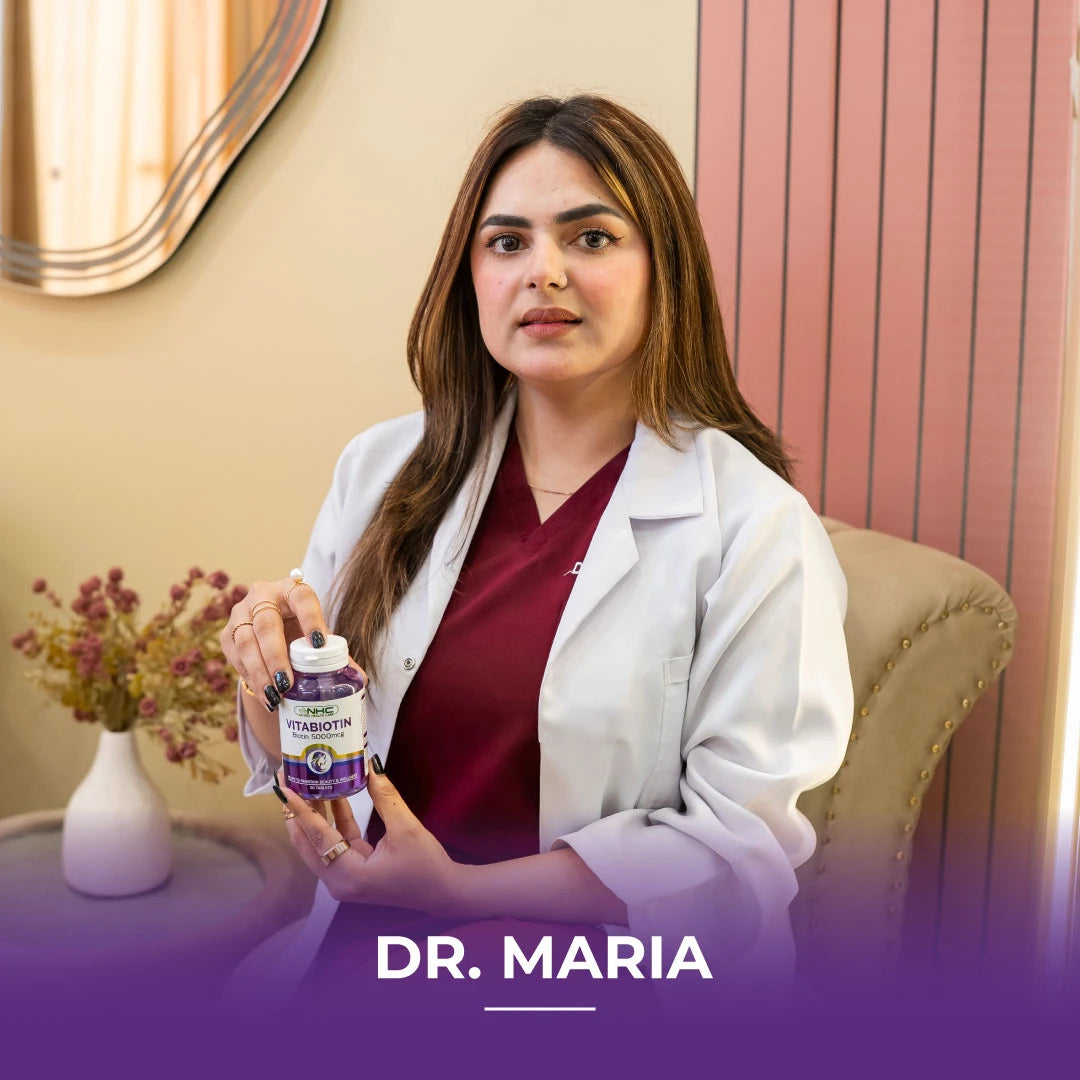  Dr. Maria in white lab coat holding NHC VitaBiotin 5000mcg biotin supplement bottle at her clinic