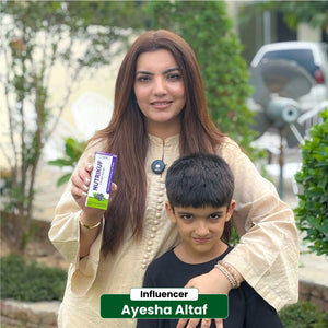 Influencer Ayesha Altaf holding NHC Nutrikuf Cough Syrup with her son outdoors