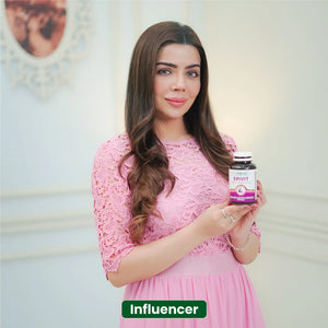 Influencer holding NHC Epivit Skin Hair and Nails softgels supplement while wearing pink dress