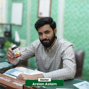 Doctor Arslan Aslam holding NHC Multi-W One A Day Women multivitamin at clinic desk