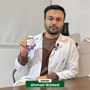Doctor Ahmad Waleed holding NHC VitaBiotin Biotin 5000mcg supplement bottle in clinic