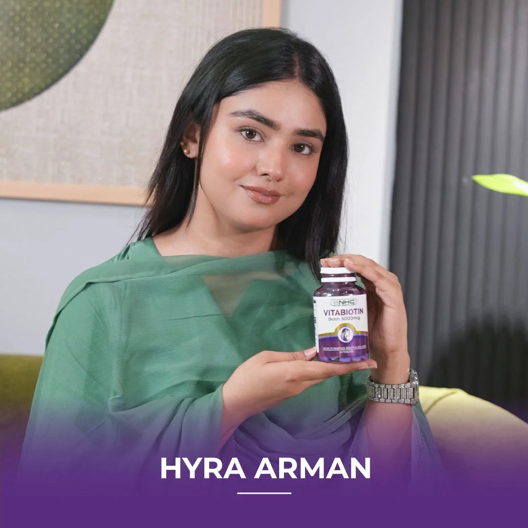 Influencer Hyra Arman holding NHC Vitabiotin 5000mcg biotin supplement bottle