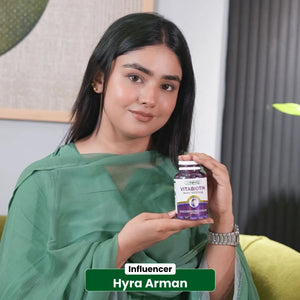 Influencer Hyra Arman holding NHC Vitabiotin 5000mcg biotin supplement bottle